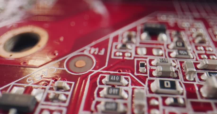 Close up of a red circuit board with metal and plastic components