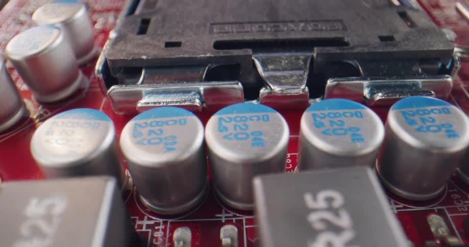 Extreme close up of the components on a red computer motherboard
