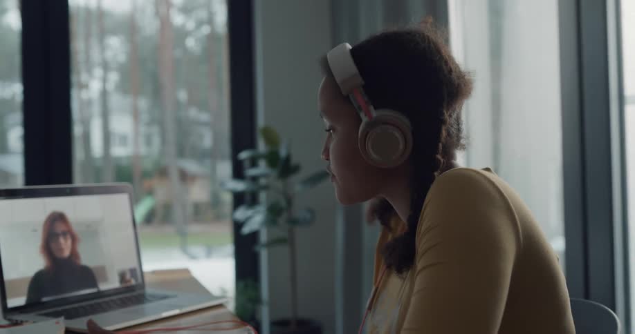 Girl receiving an online class at home doing homework