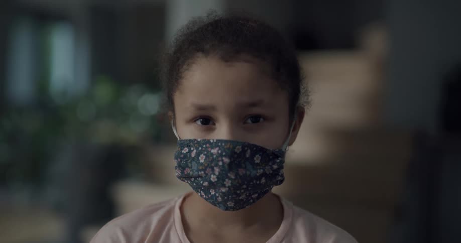 A child is wearing a blue mask with flowers on it