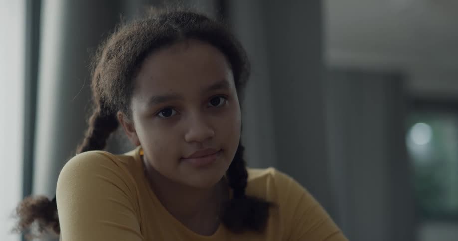 A girl in a room staring and smiling