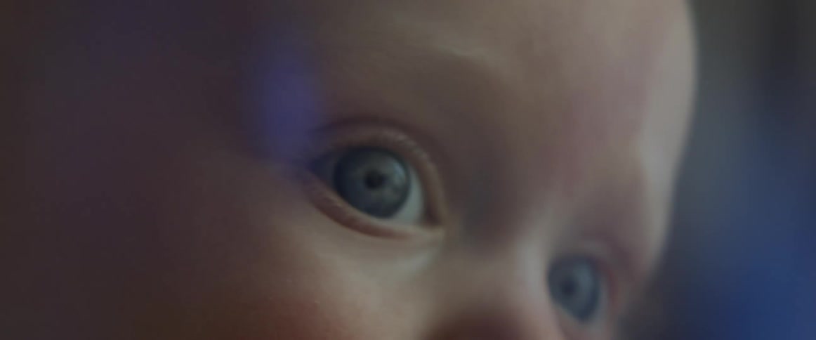 The upper face of a baby as it looks around