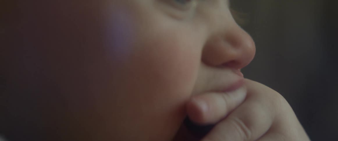 Side view of a baby sucking his fingers