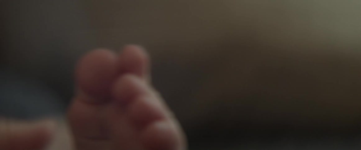 A soft white infant foot is moving around