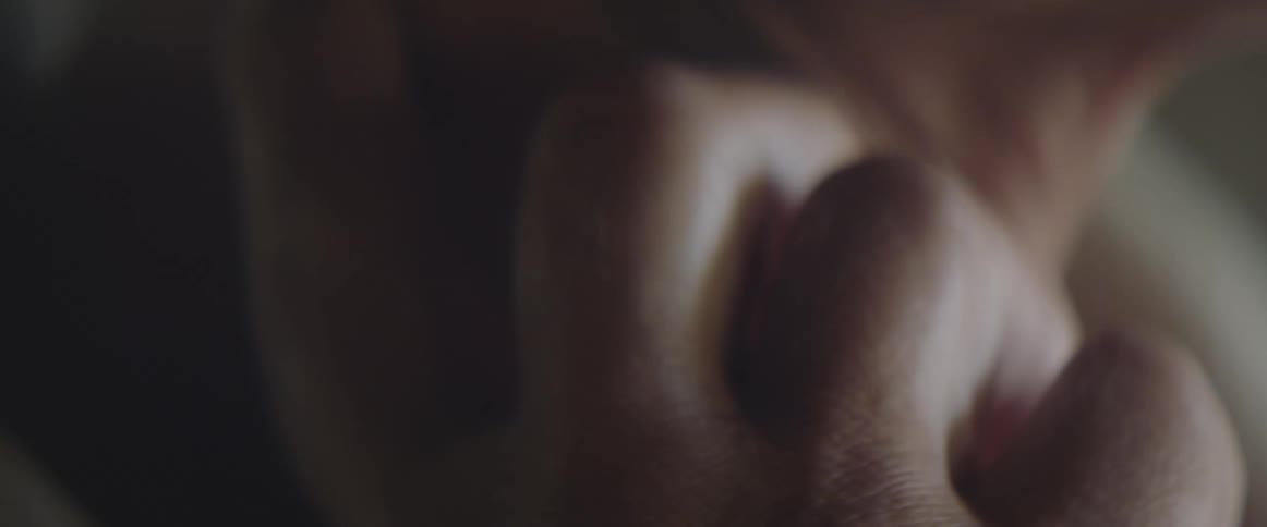 An elderly persons hand and fingers are resting on their neck