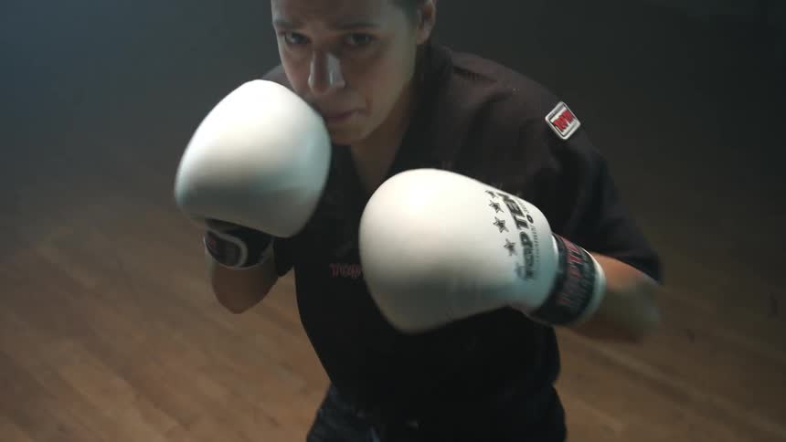 A woman practices boxing with a man