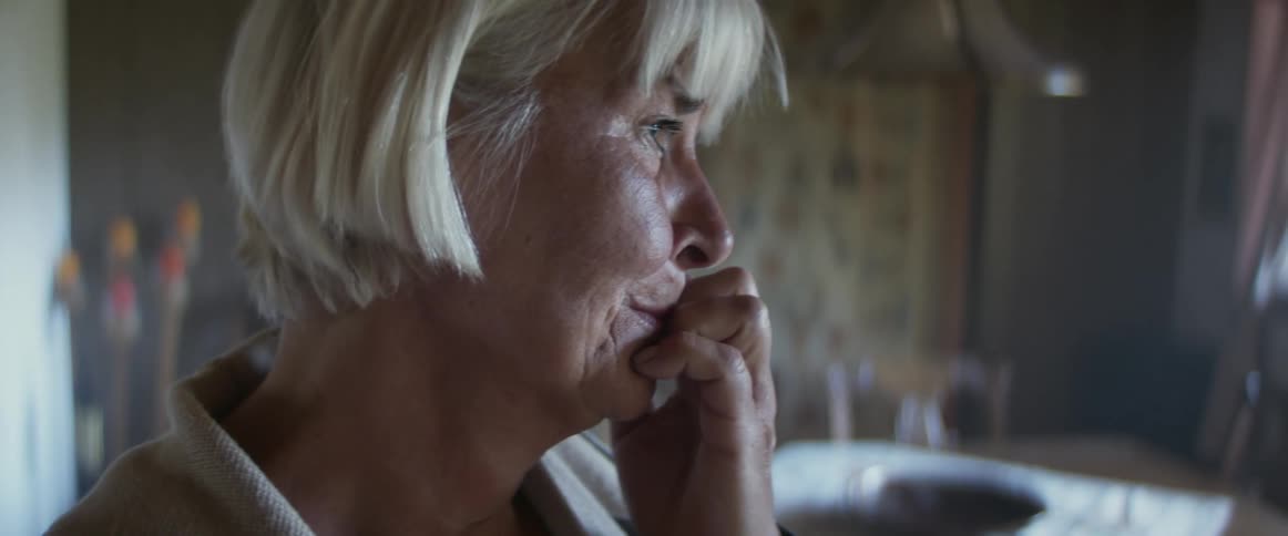 An elderly woman at home crying