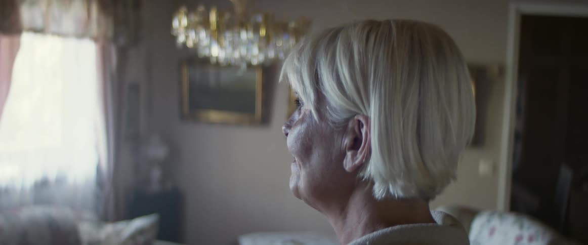 Elderly woman looking out the windows and cries as the result of a strong emotion
