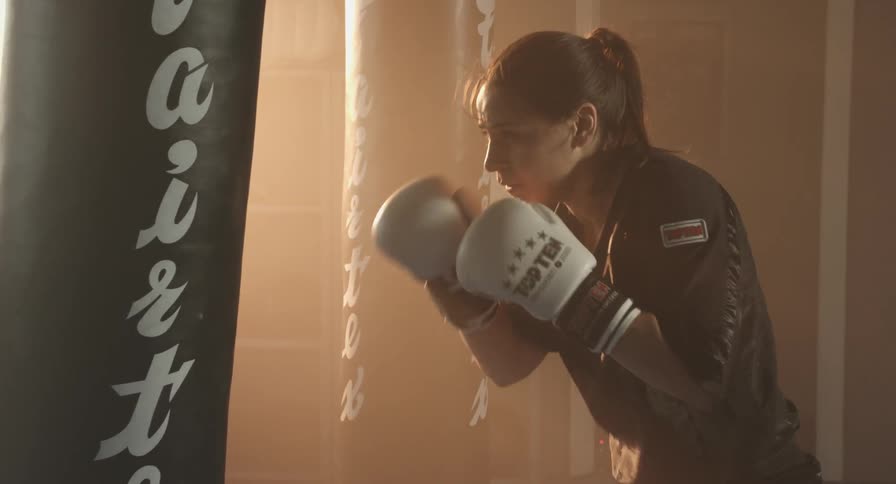 A woman hits a punching a bag