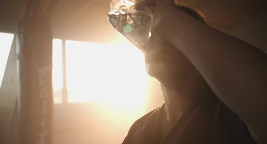 A woman is gulping a bottle of water