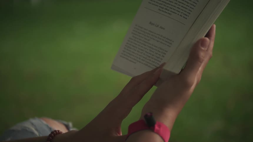 Person holding open a book they are reading