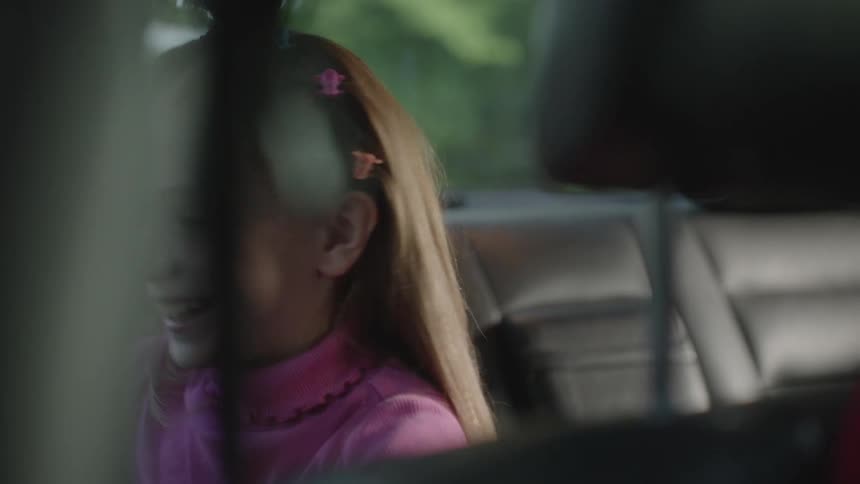 Excited little girl opening car door then getting out
