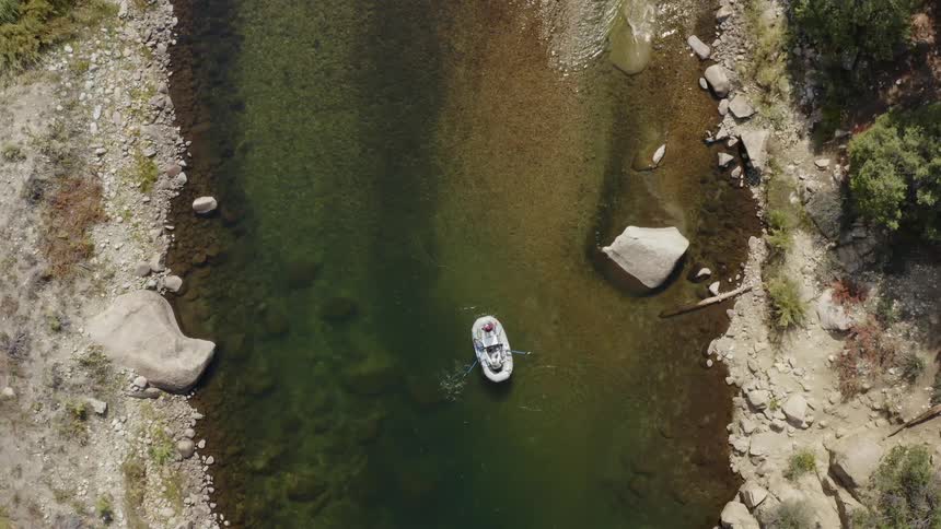 A raft is being paddled down a river during the day