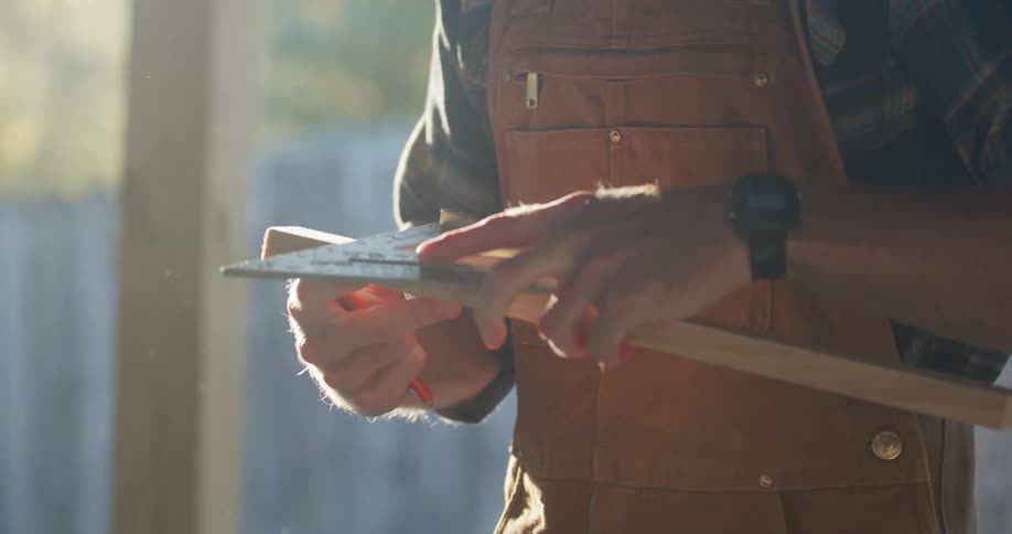 A carpenter uses a triangle and measures pieces of wood