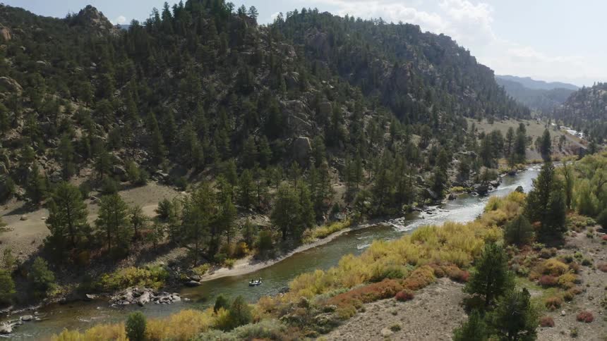 An aerial view of a river surrounded by trees and mountains