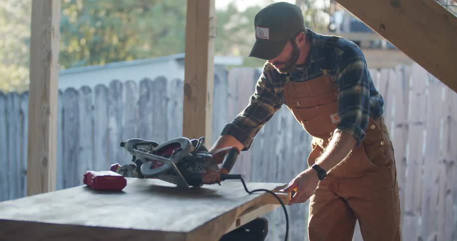 A carpenter measures wood and writes on it