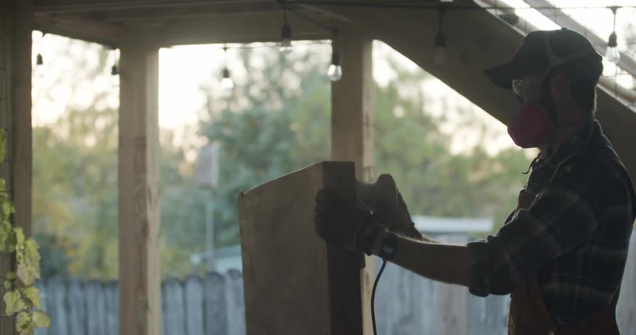 A man sanding wood with a power tool
