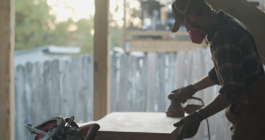 A man working on a piece of wood with power tools
