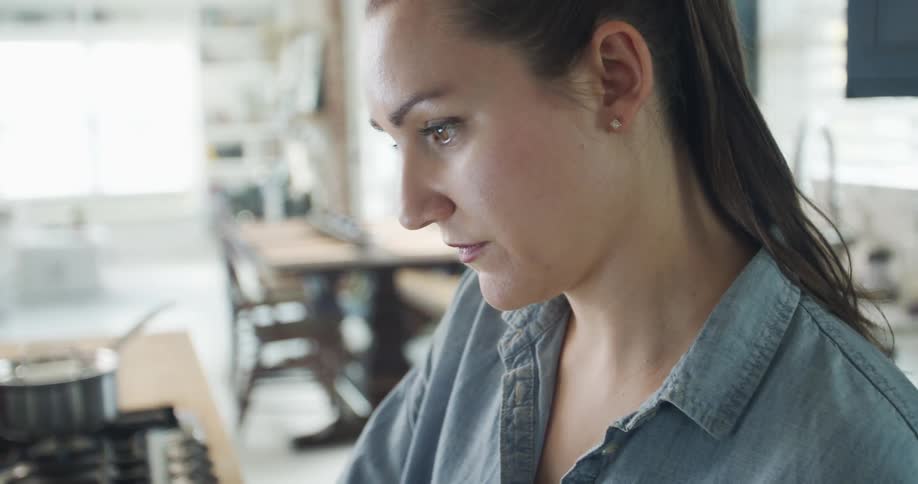 Woman concentrates while cooking in the kitchen at home