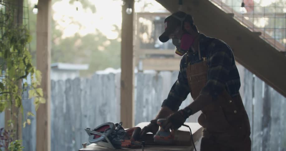 A man uses power tools to sand wood