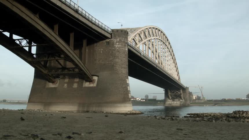 A bridge over water with buildings in the distance