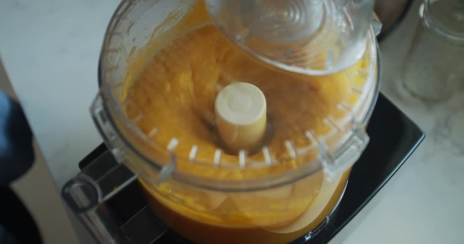 Person runs food processor on yellow mixture
