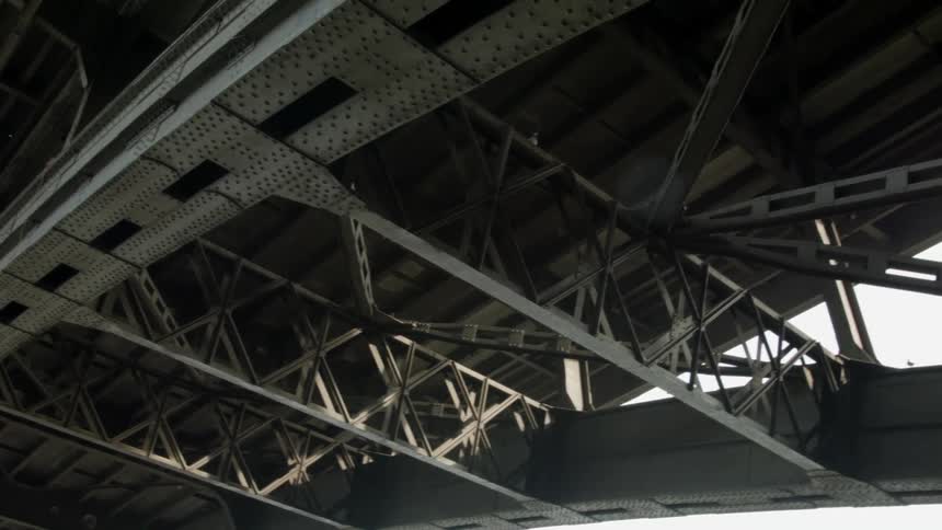 A bird flies under the bridge