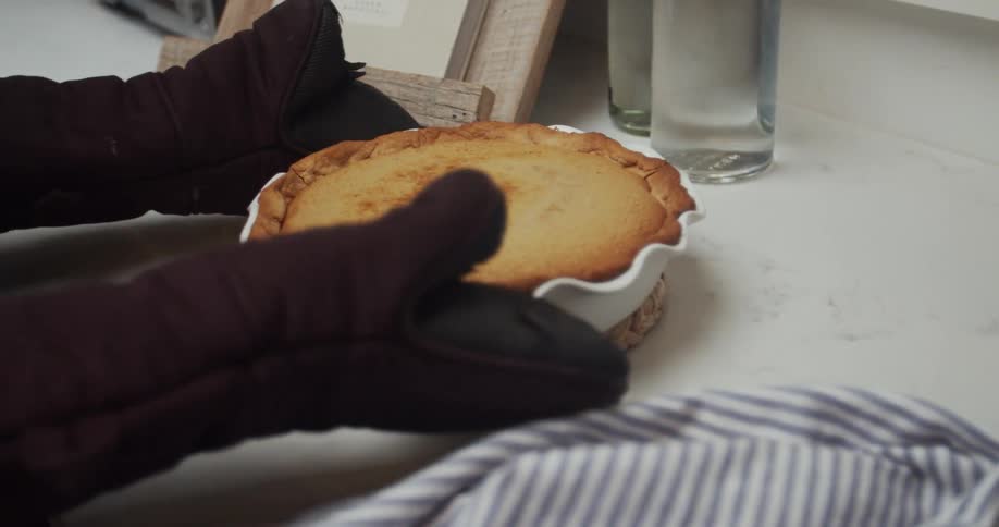 A person places a hot pie on the counter