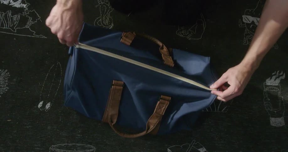 Person puts book in blue bag