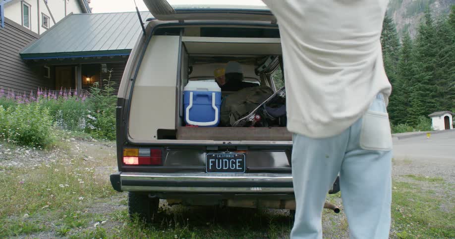 A man closes the back of his van and walks around front