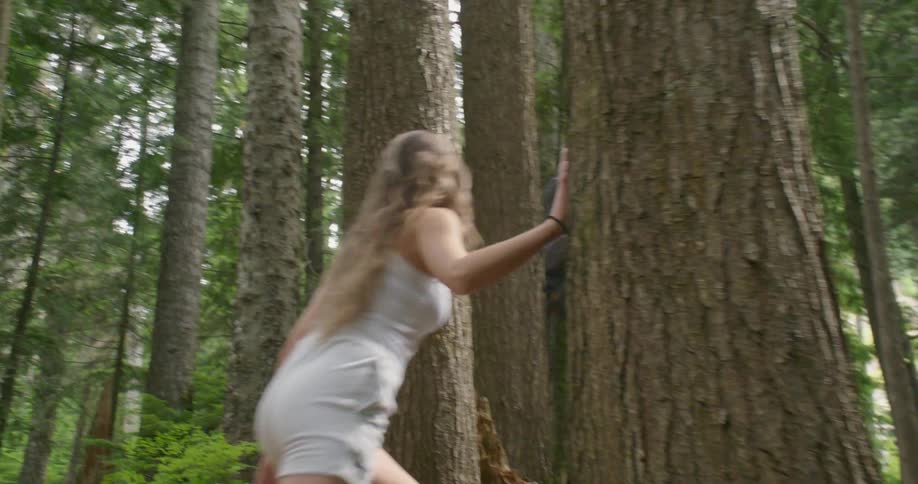 A man and woman hike together through a woodland during the day