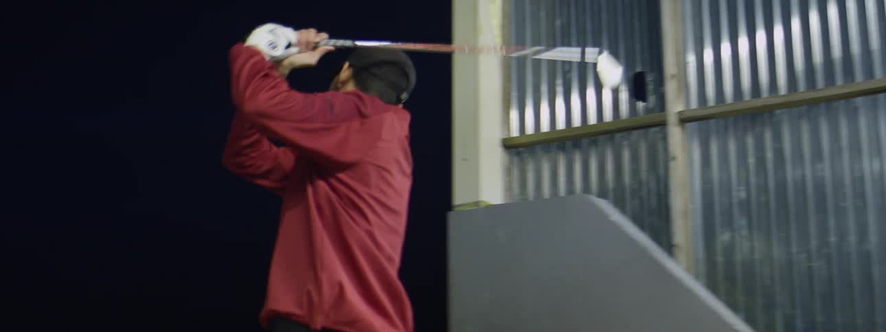 A man practices swinging his golf club indoors