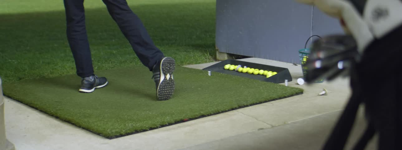 A man shooting golf balls at a driving range