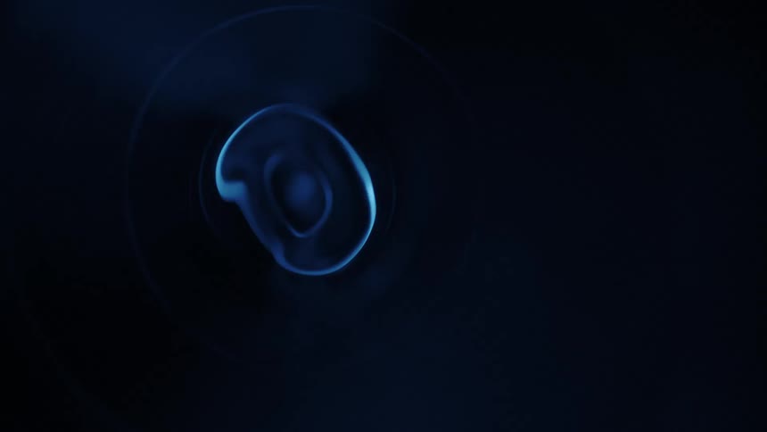 Spinning blue fosforescent lights inside a dark room