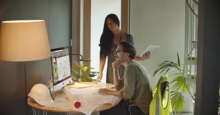 Couple working from home talk to a construction supervisor on a video call