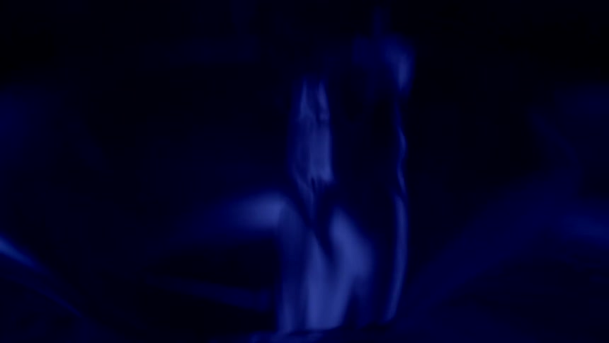 Water is rapidly poured in a hole in front of a blue material to create a ripple pattern