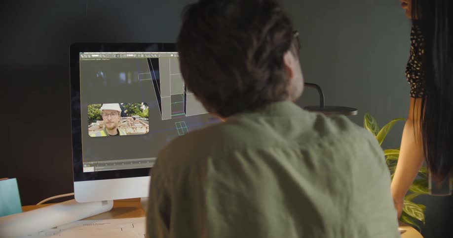 A man and woman discuss the design of a building with a colleague via video chat