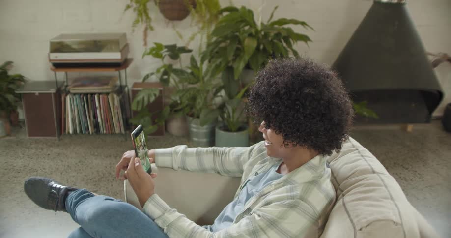 A woman is talking on her cell phone in the living room
