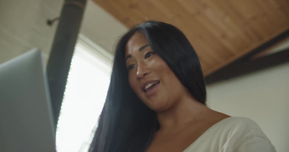 A woman smiles and gestures as she talks on a video call