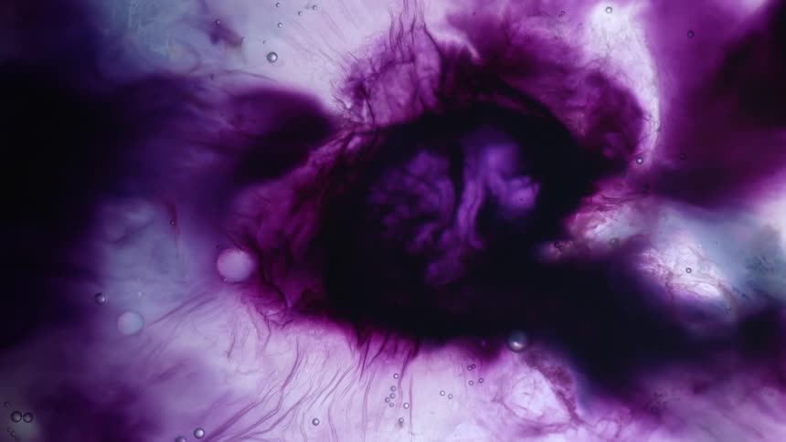 A purple liquid of different shades under a microscope flows and forms bubbles