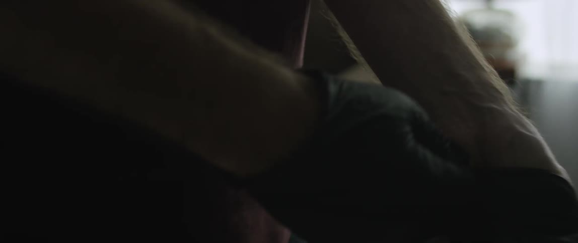 A man putting on a pair of latex gloves