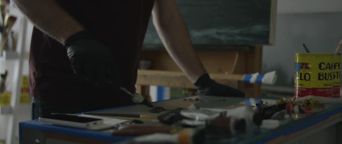 A man is mixing paints on a board