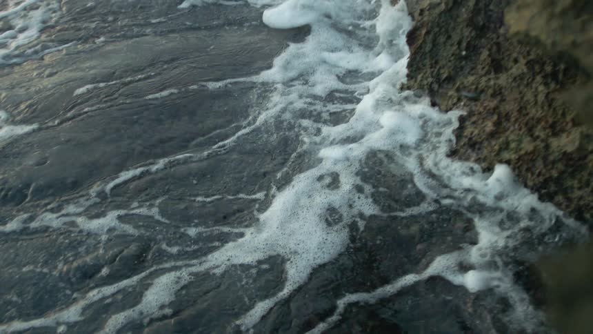 A shot of waves hitting a cliff