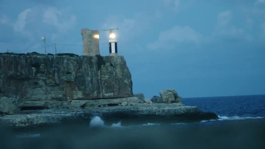The lighthouse is flashing near the shore
