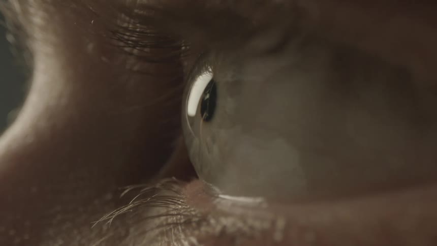 Close up of a womans hazel eye moving while looking