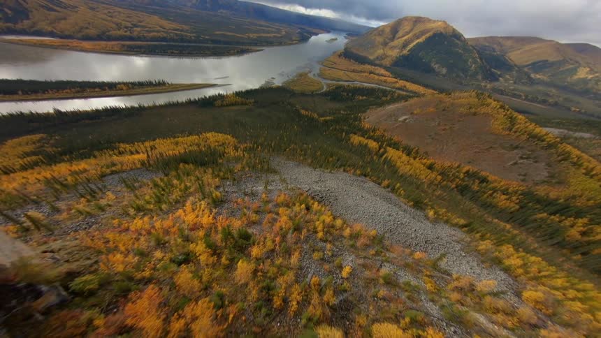 Aerial view of mountains and a river with a cloudy sky