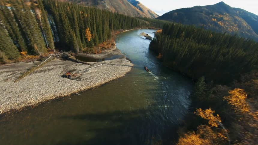 Aerial shot of a forest river with a boat on it