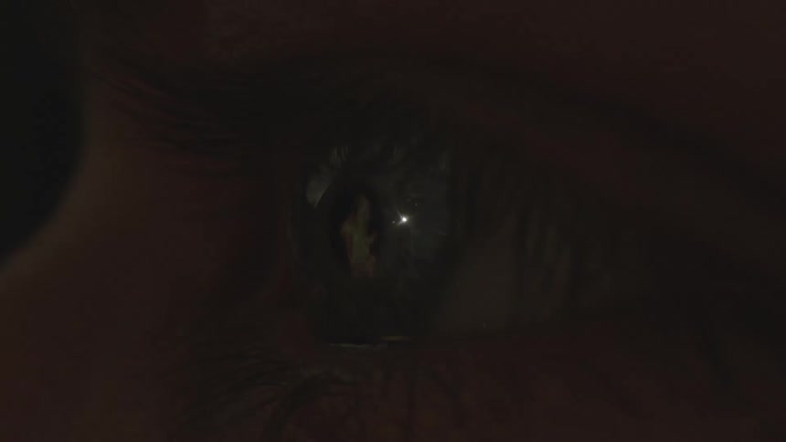 Close up of a blue eye staring at a fire flame as blue and red lights flash on and off