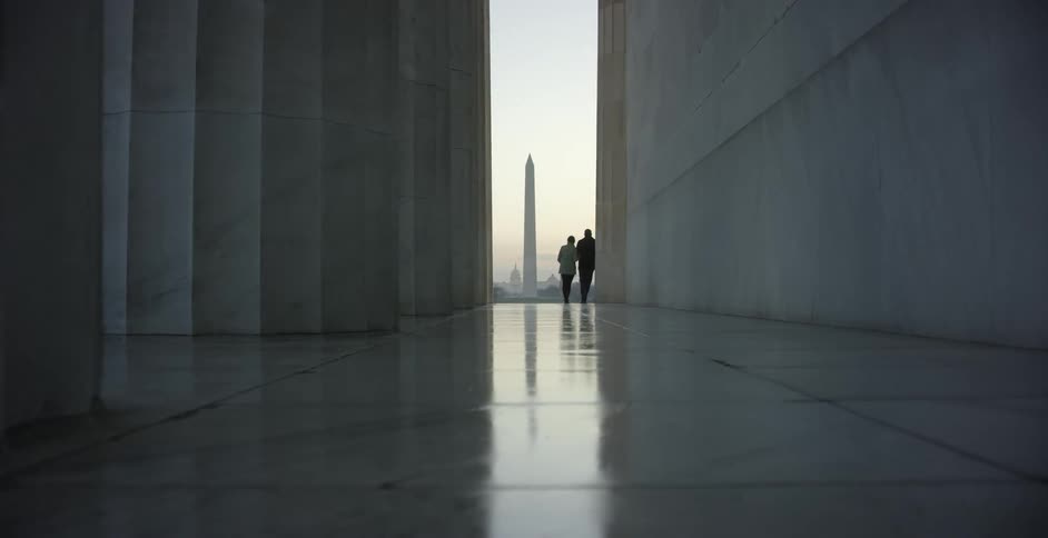 Couple contemplating the washington monument in the national mall at evening