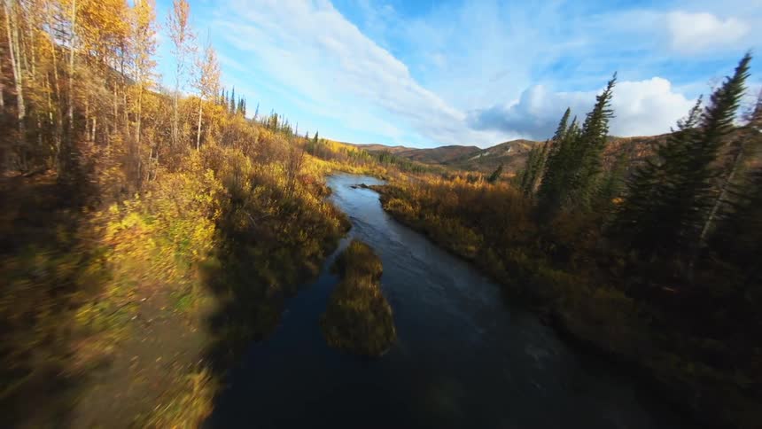 River in mountainous forest area with a mountain in the distance on a cloudy day
